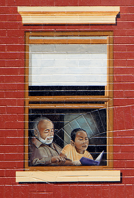 grandfather helping grandson with his reading
