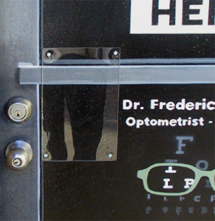 a protective clear acrylic shield was screwed on the first door next to the handle