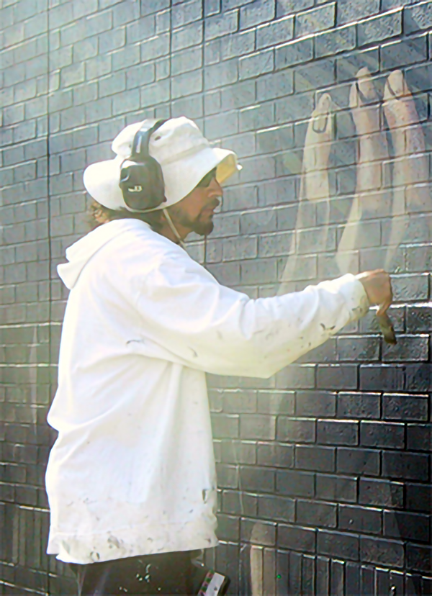 detail of john wearing ear mufflers while painting